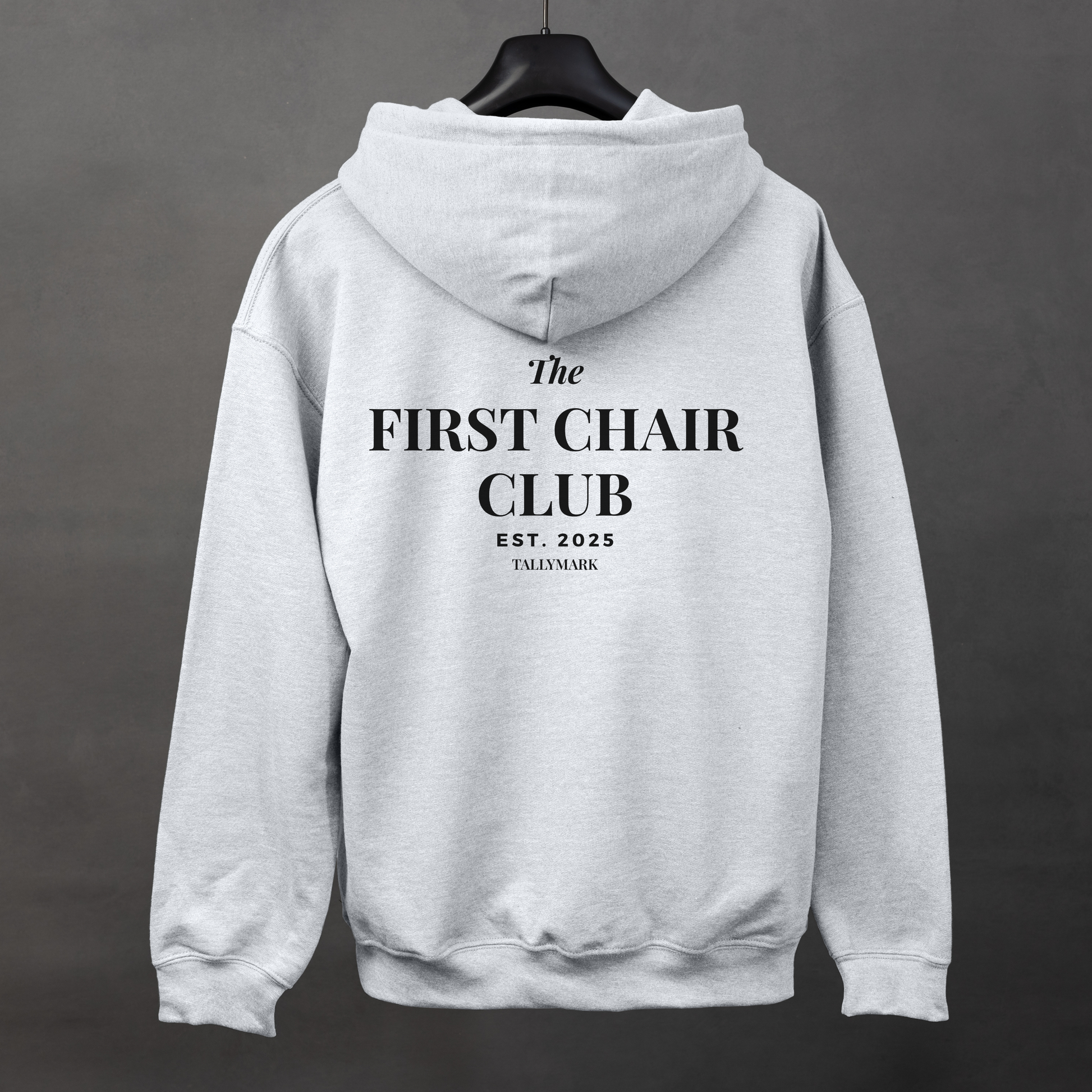 Gray hoodie with 'The First Chair Club' text on the back against a dark background