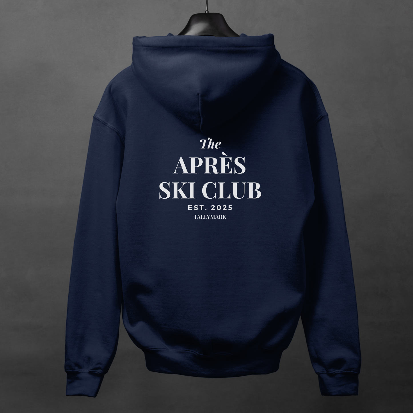 Navy blue hoodie with 'The Après Ski Club' text on the back against a dark background