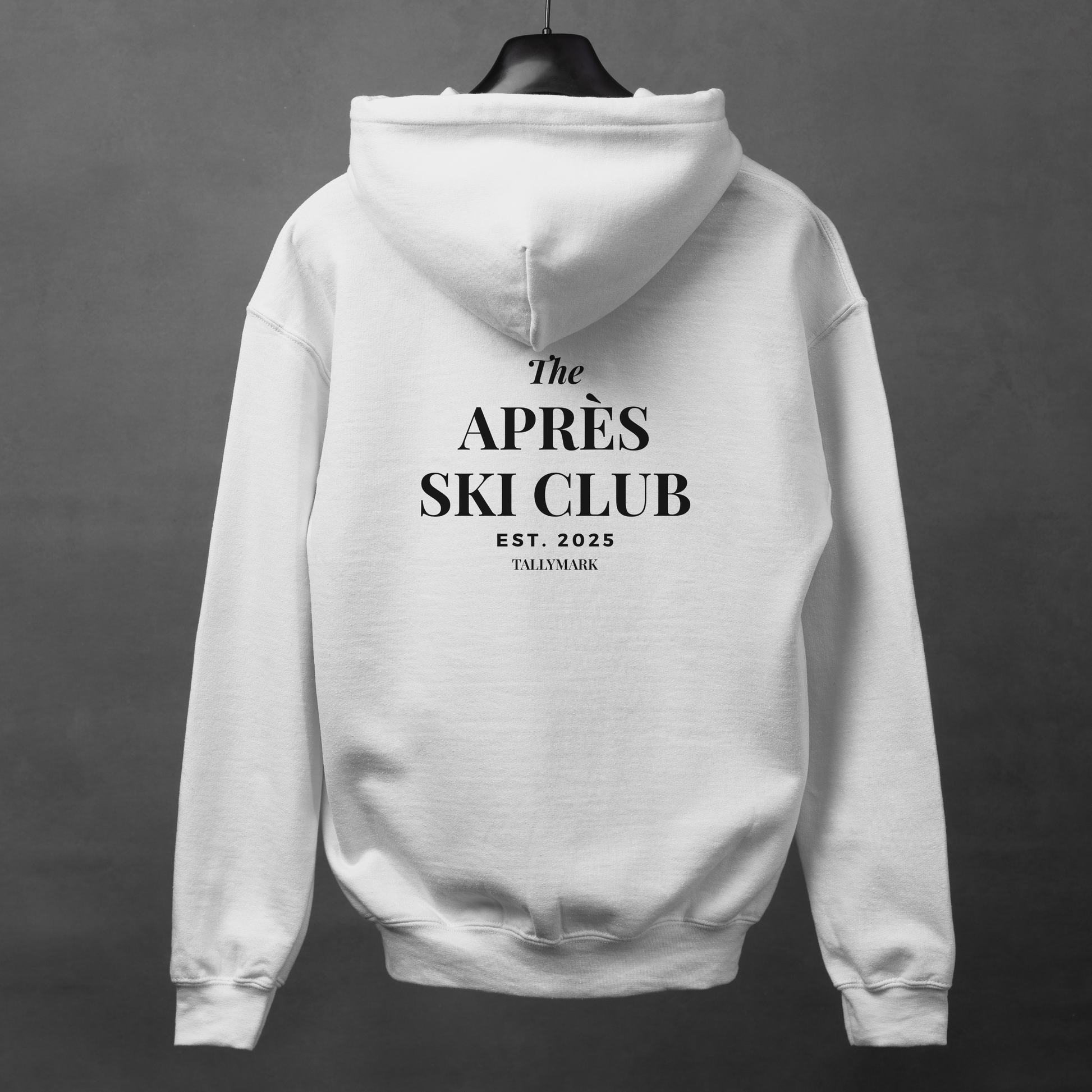 White hoodie with 'The Après Ski Club' text on the back against a dark background