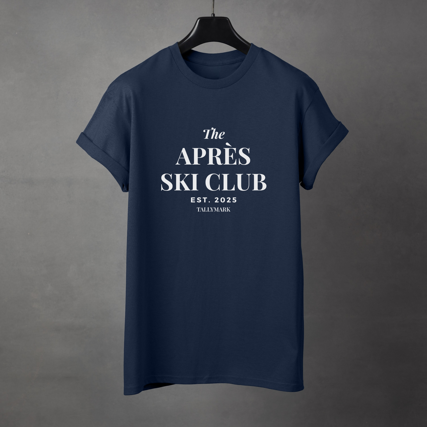 Navy blue t-shirt with 'The Après Ski Club' text on a gray background
