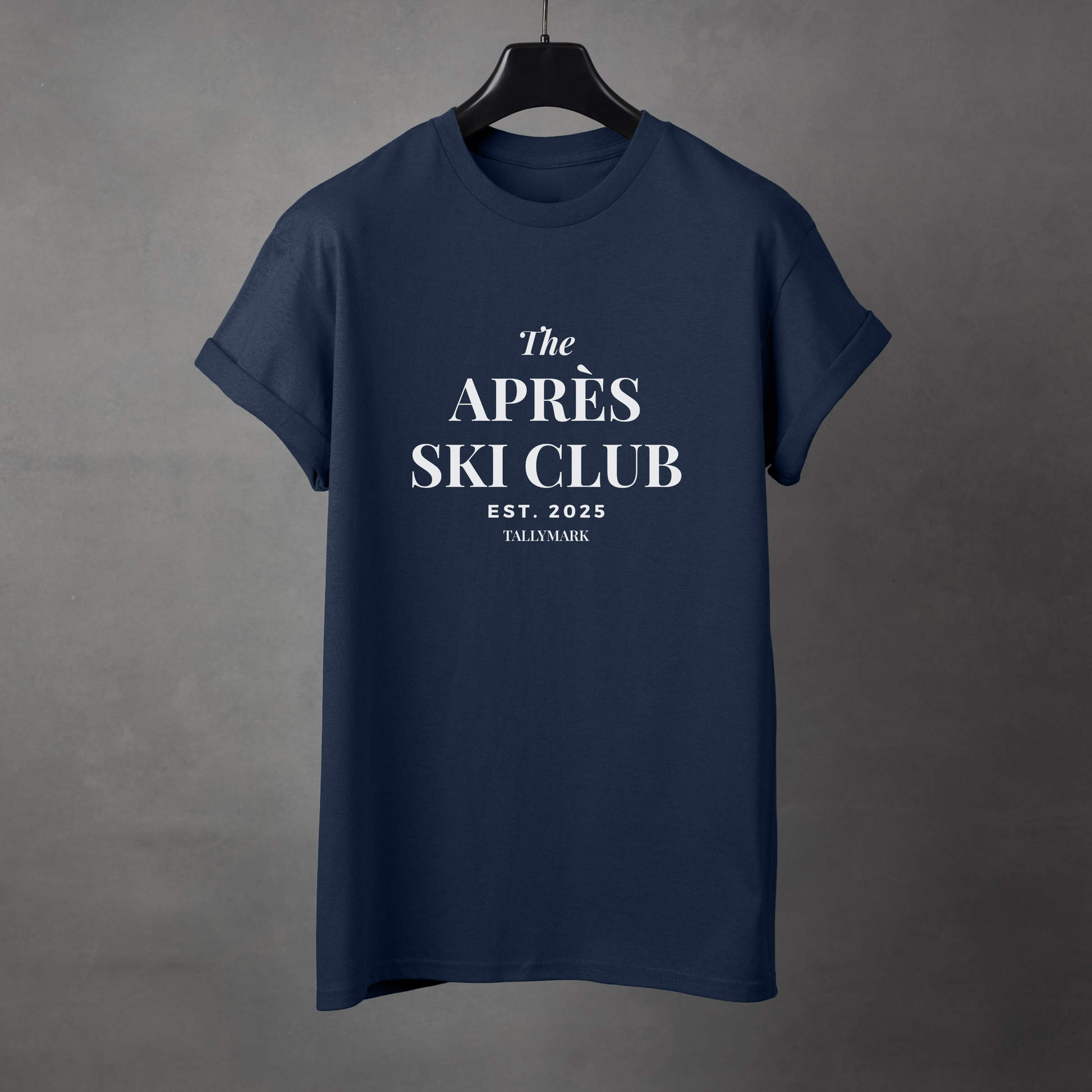 Navy blue t-shirt with 'The Après Ski Club' text on a gray background