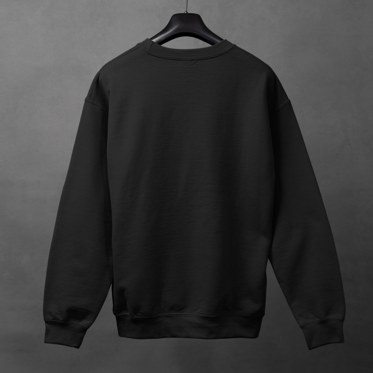 Black sweatshirt on a hanger against a gray background