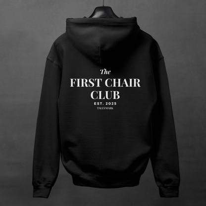 Black hoodie with 'The First Chair Club' text on the back against a dark background