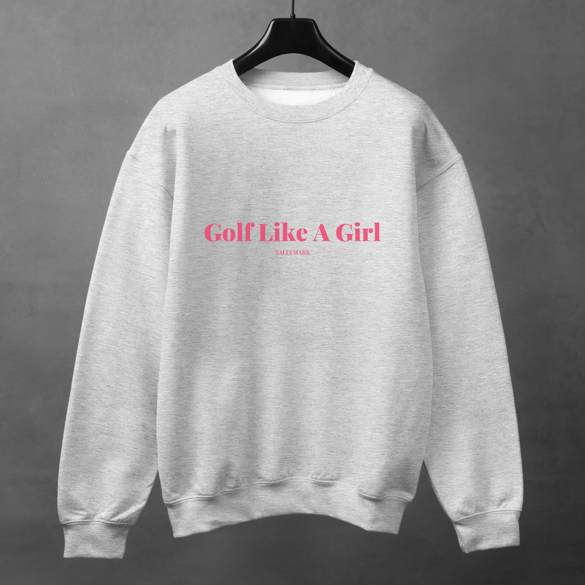 Gray sweatshirt with pink 'Golf Like A Girl' text against a dark background