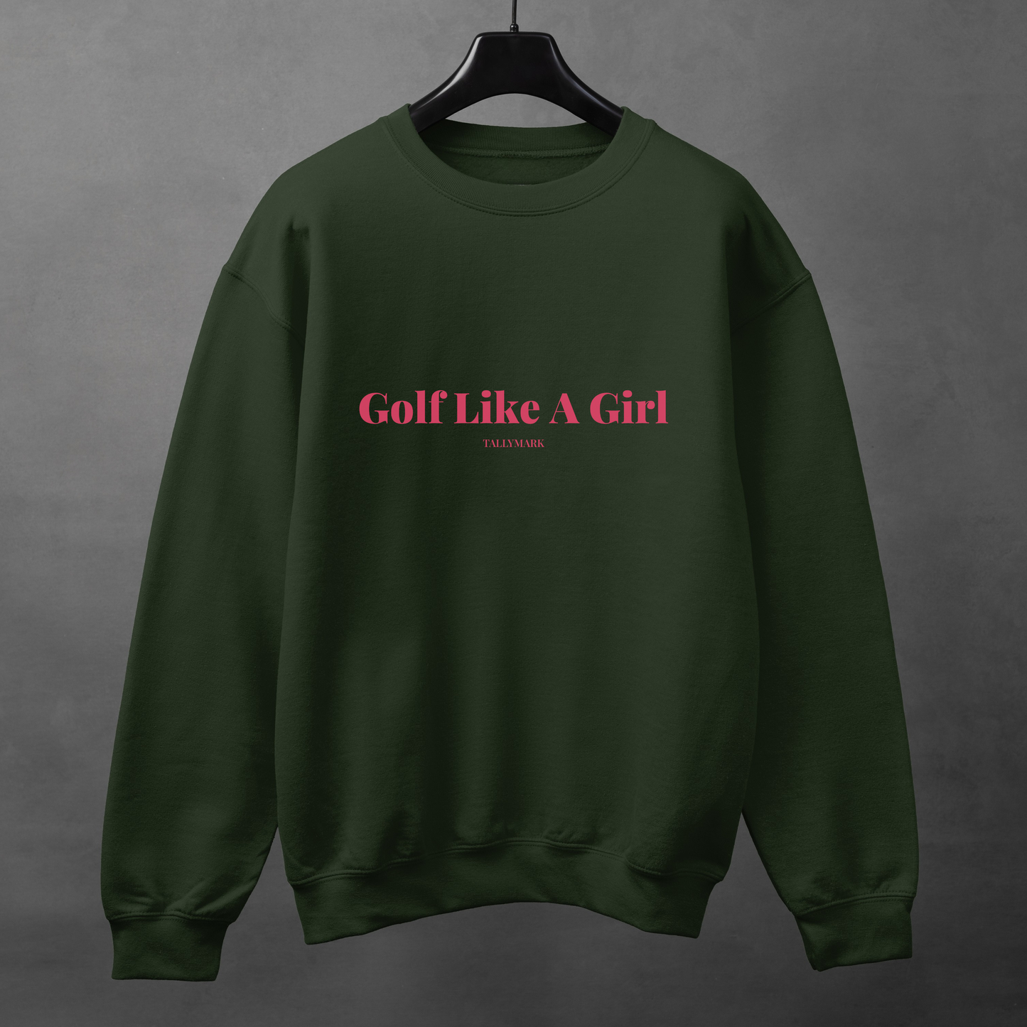 Green sweatshirt with pink 'Golf Like A Girl' text against a dark background