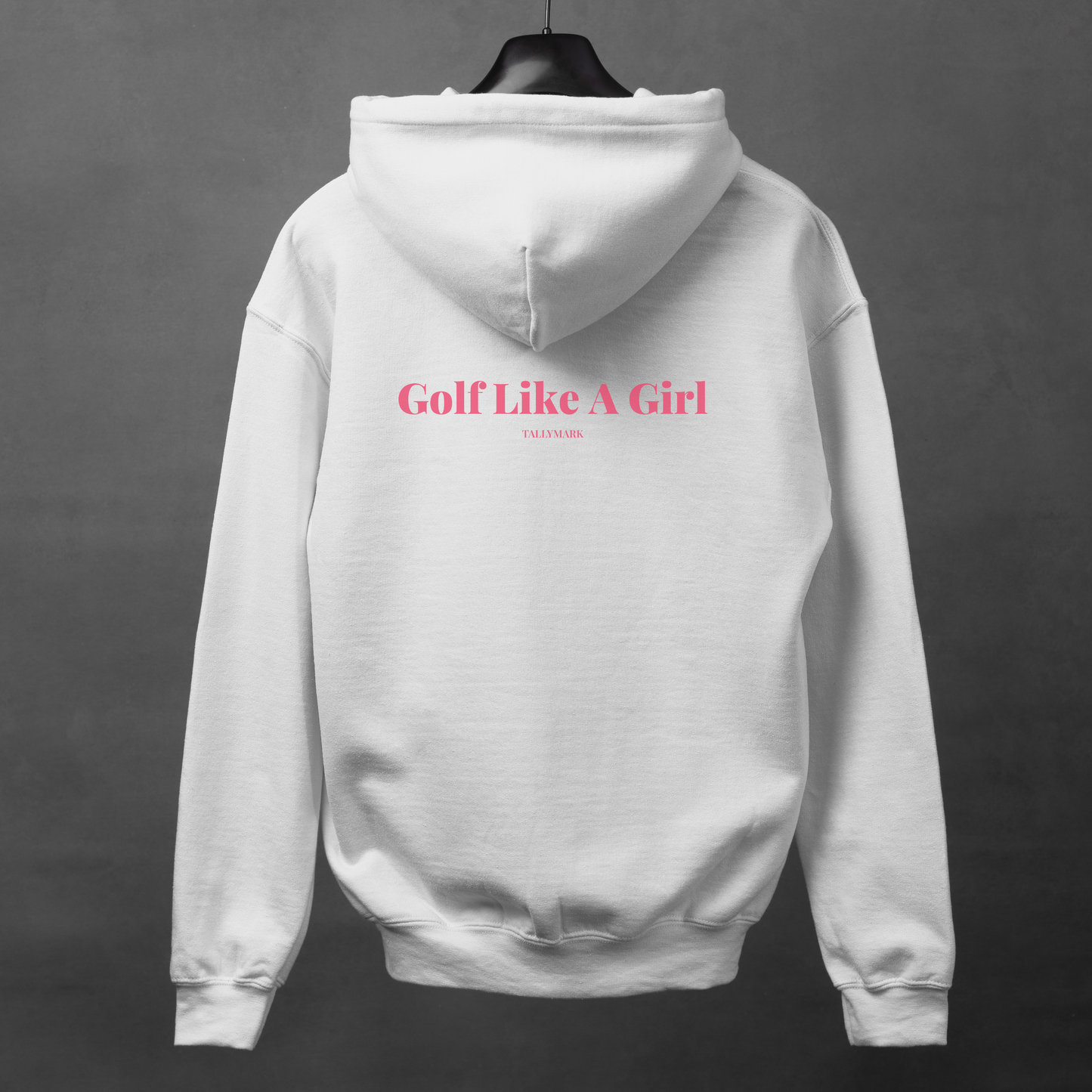 White hoodie with pink "Golf Like A Girl" text on the back against a dark background