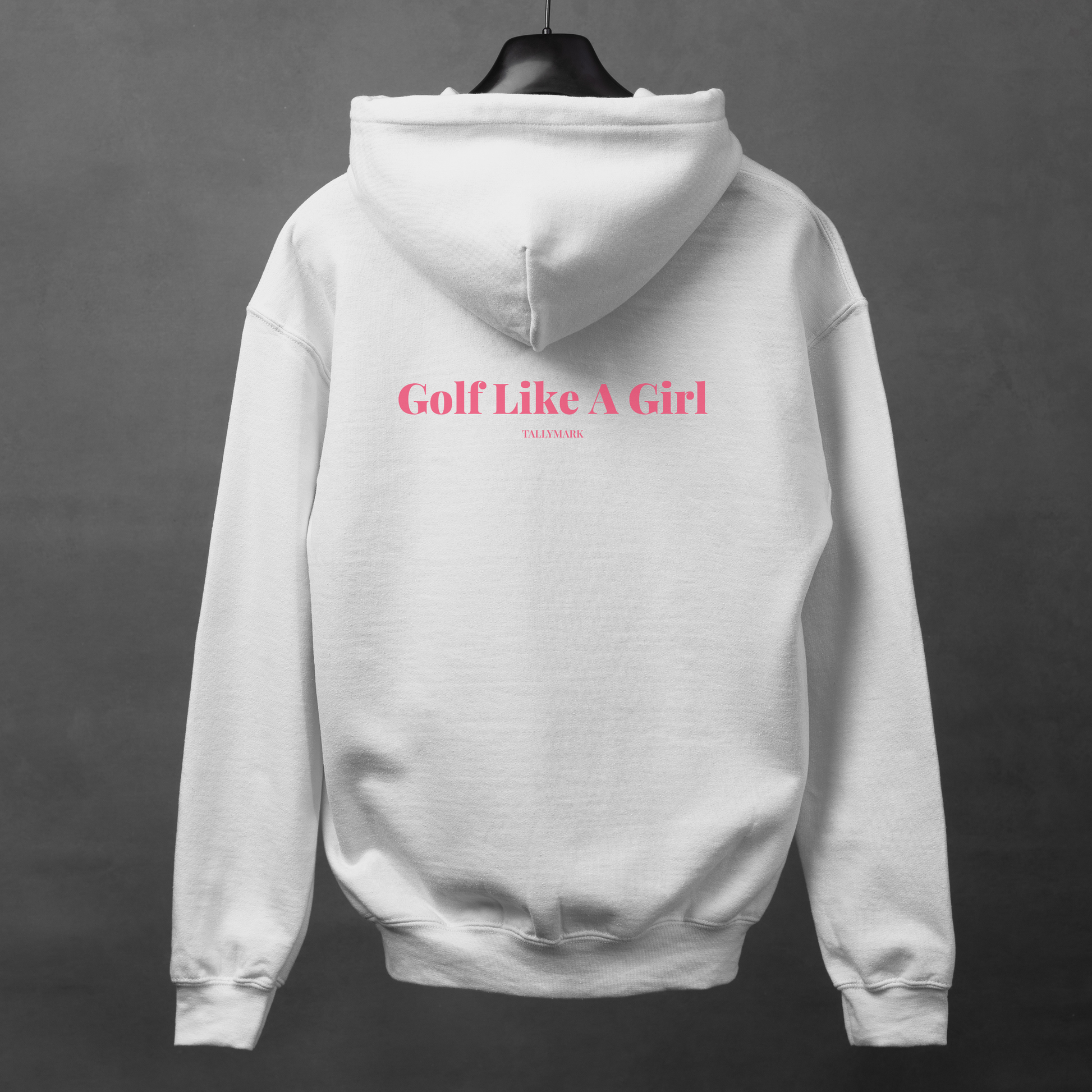 White hoodie with pink "Golf Like A Girl" text on the back against a dark background