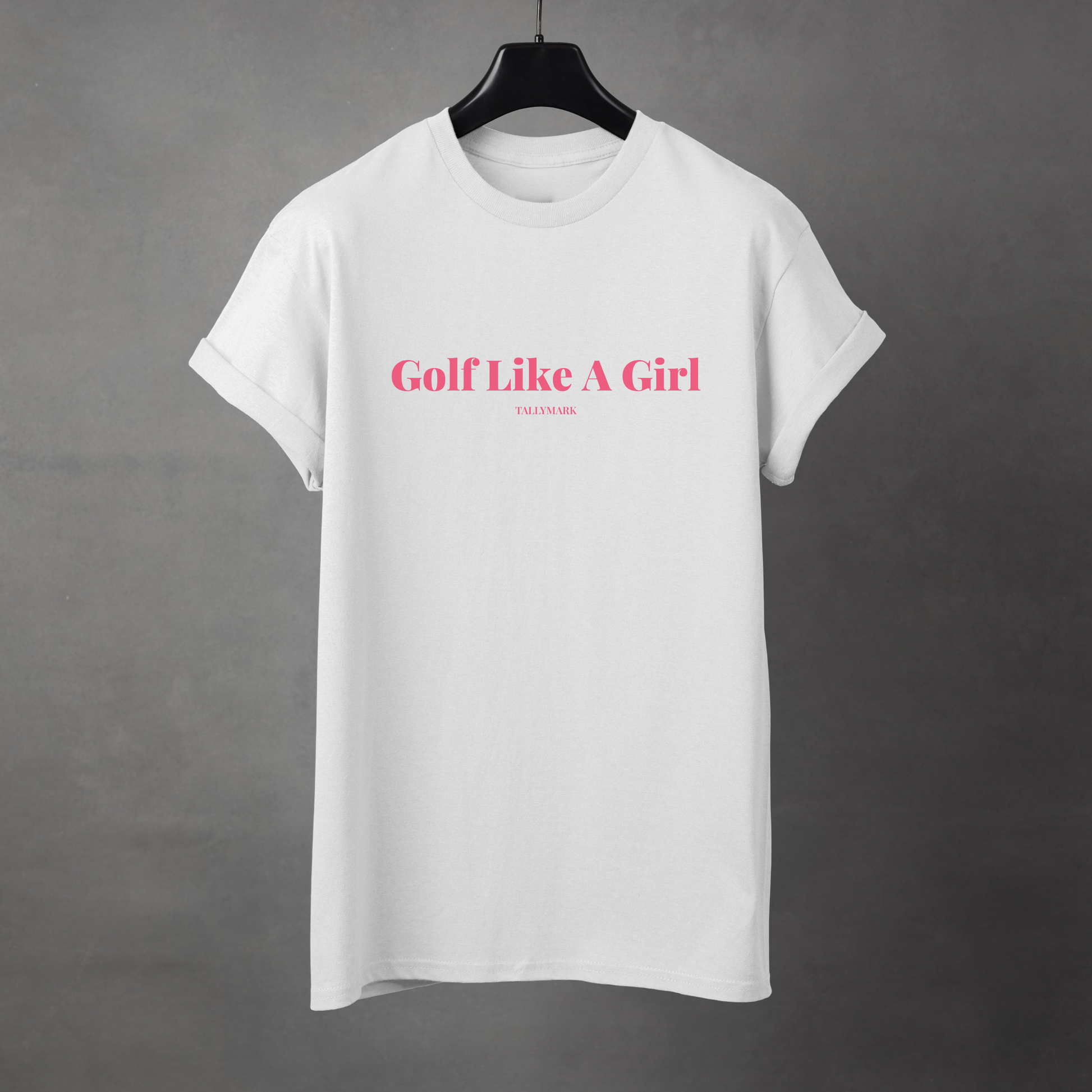 White t-shirt with pink 'Golf Like A Girl' text against a dark background
