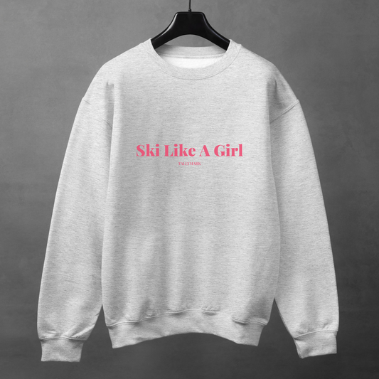 Gray sweatshirt with pink 'Ski Like A Girl' text against a dark background