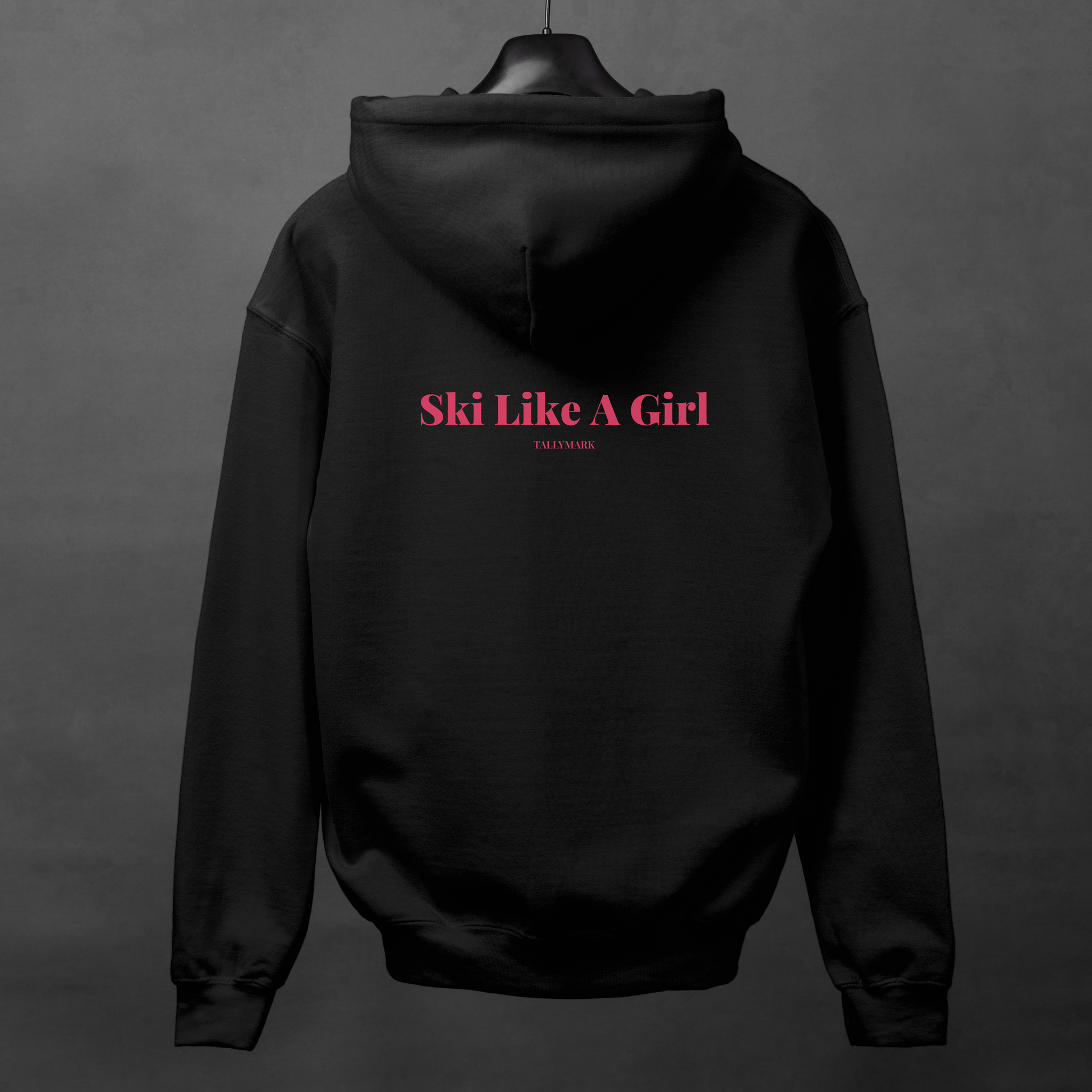 Black hoodie with pink 'Ski Like A Girl' text on the back against a dark background