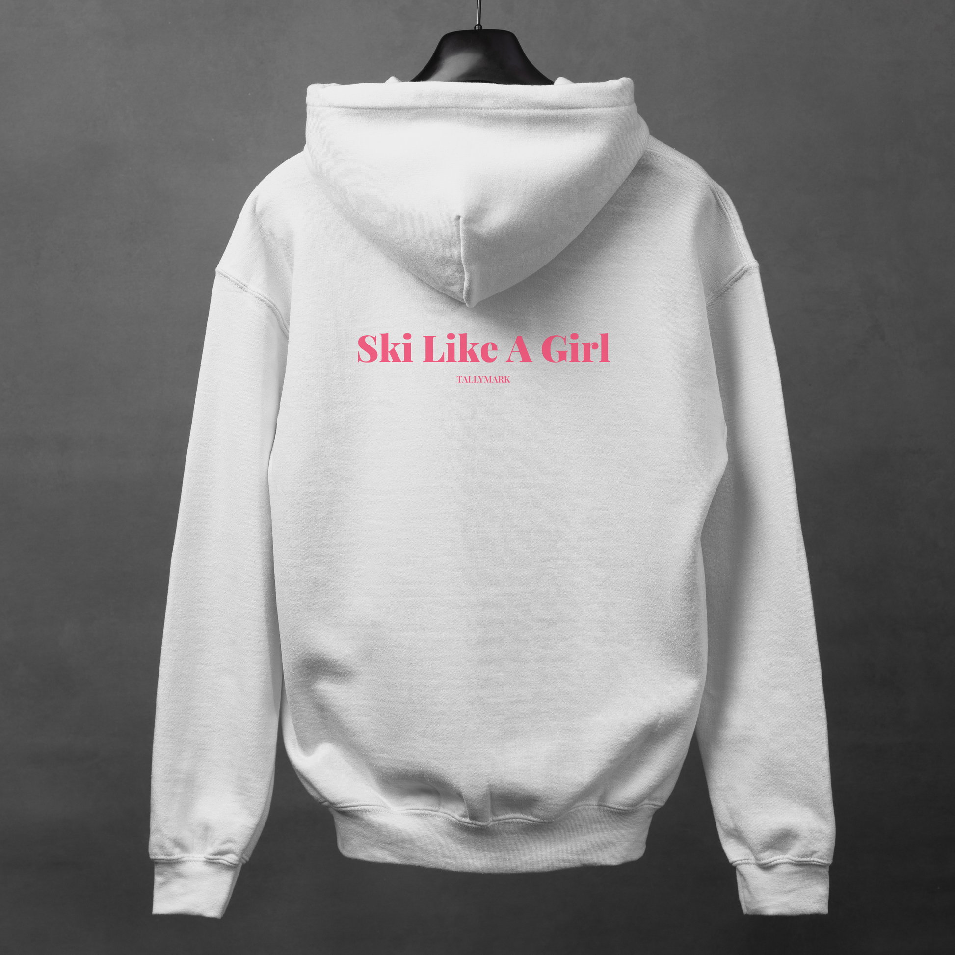 White hoodie with pink 'Ski Like A Girl' text on the back against a dark background