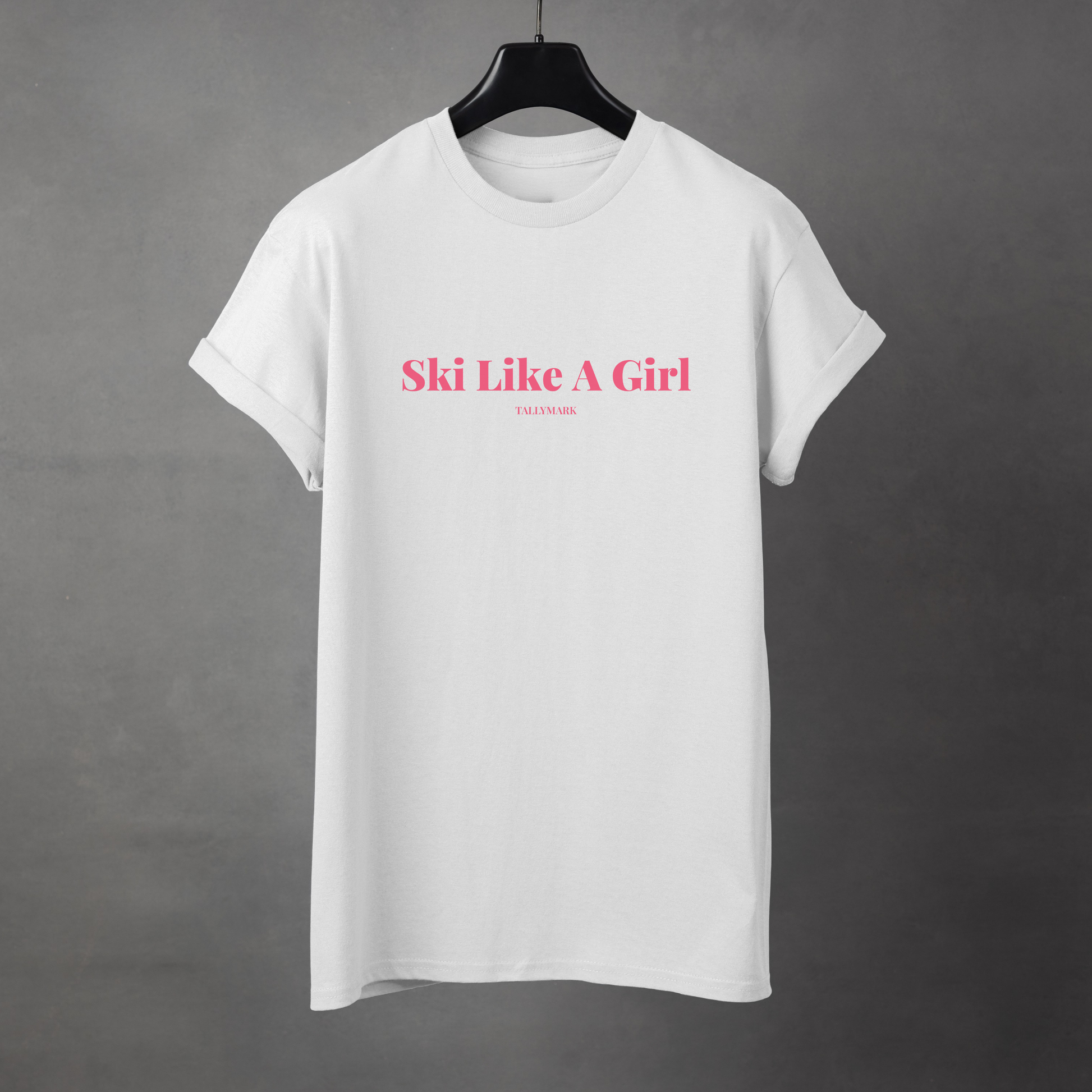 White t-shirt with pink 'Ski Like A Girl' text against a dark background