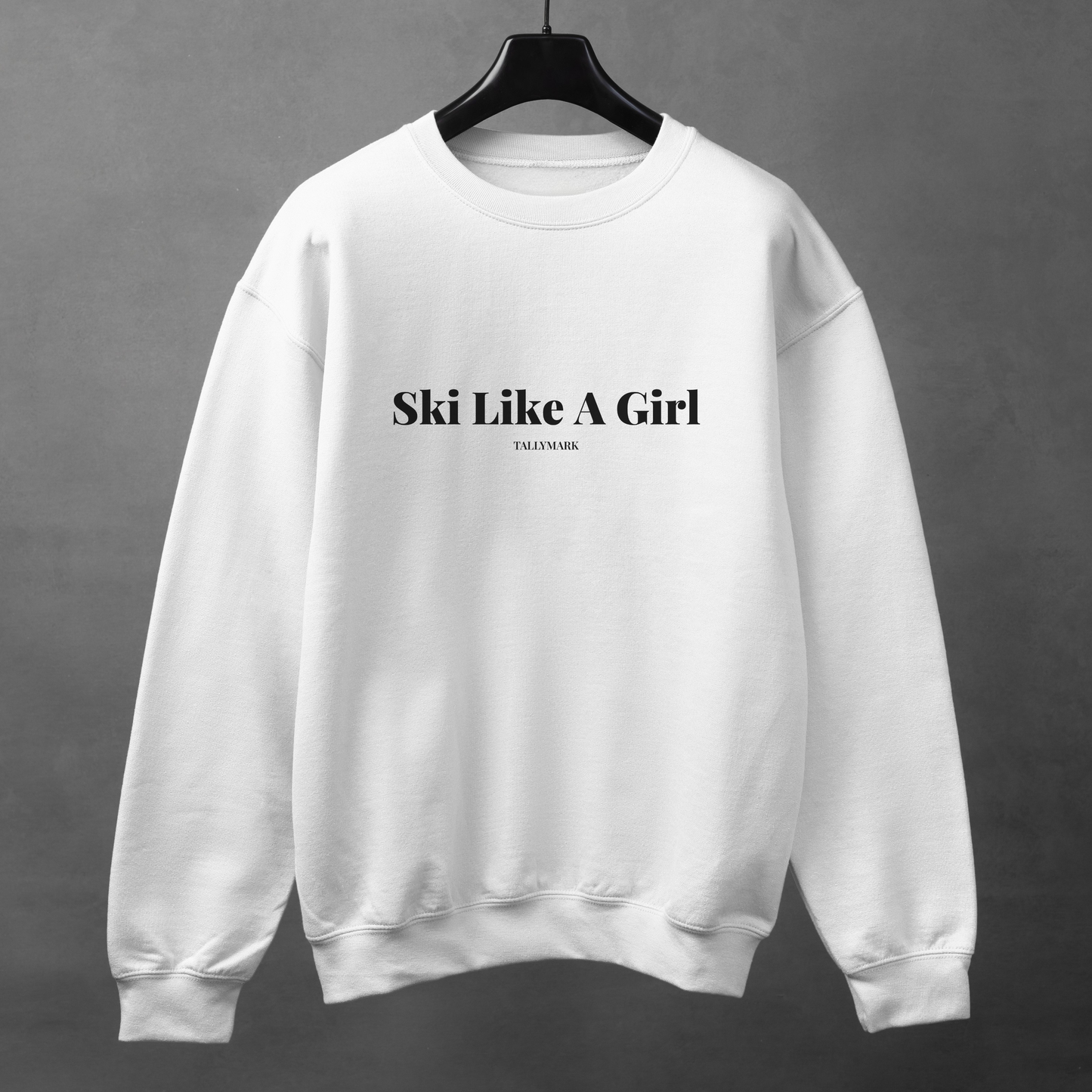 White sweatshirt with 'Ski Like A Girl' text on a gray background