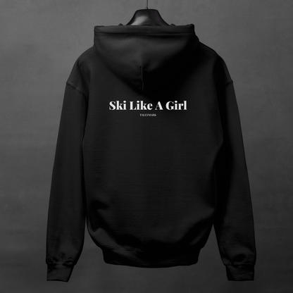Black hoodie with 'Ski Like A Girl' text on the back, displayed on a hanger against a dark background.