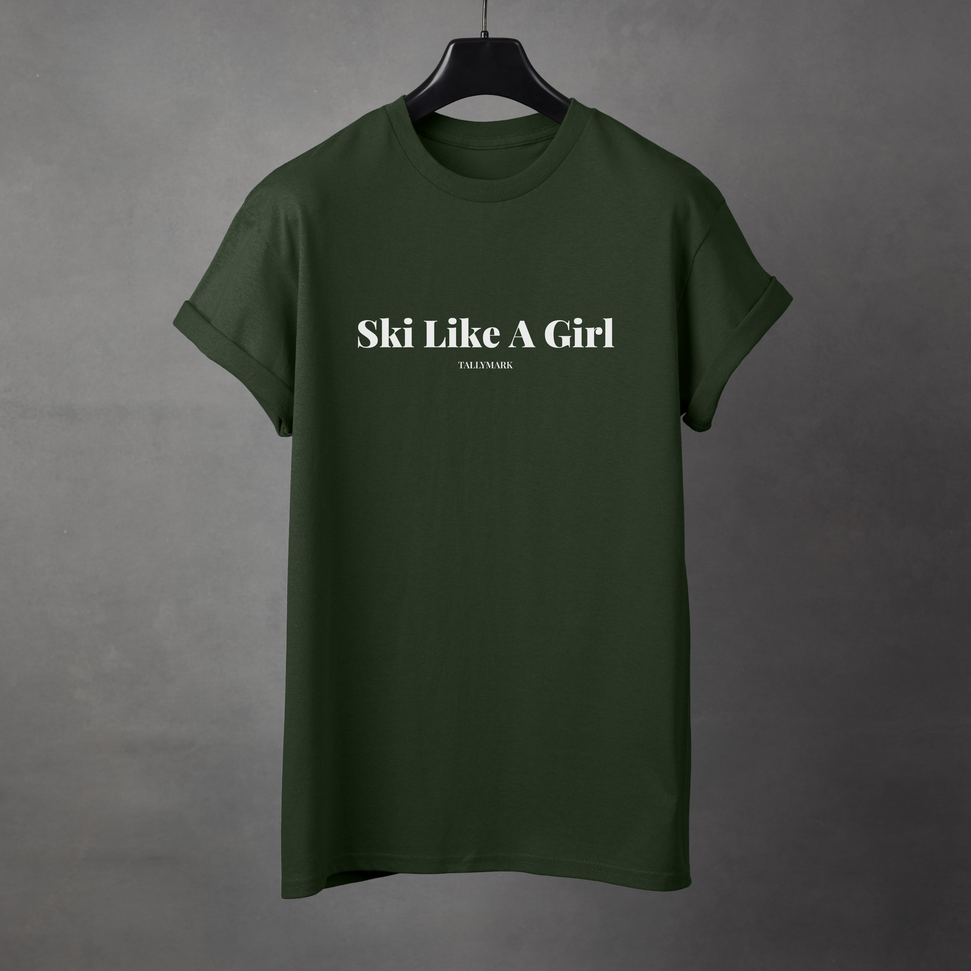 Green t-shirt with 'Ski Like A Girl' text on a gray background