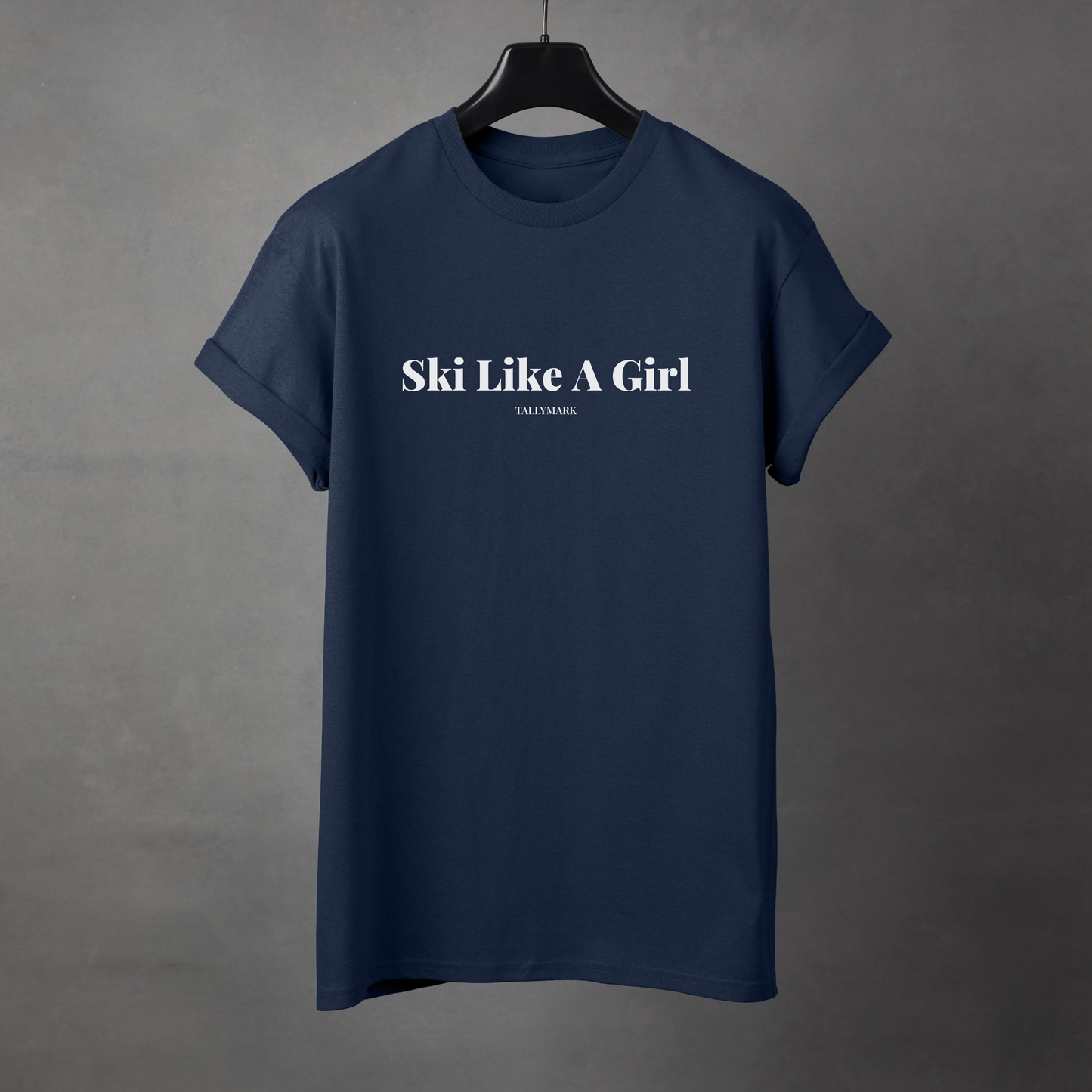 Navy blue t-shirt with 'Ski Like A Girl' text on a gray background