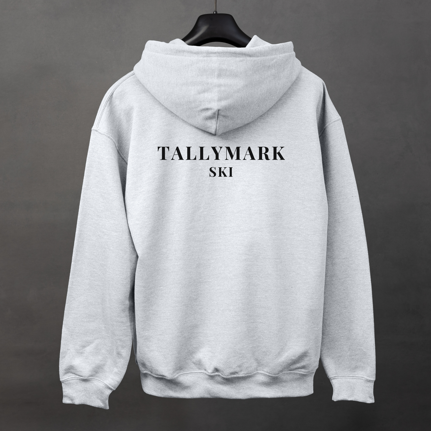 Gray hoodie with "TALLYMARK SKI" text on the back against a dark background